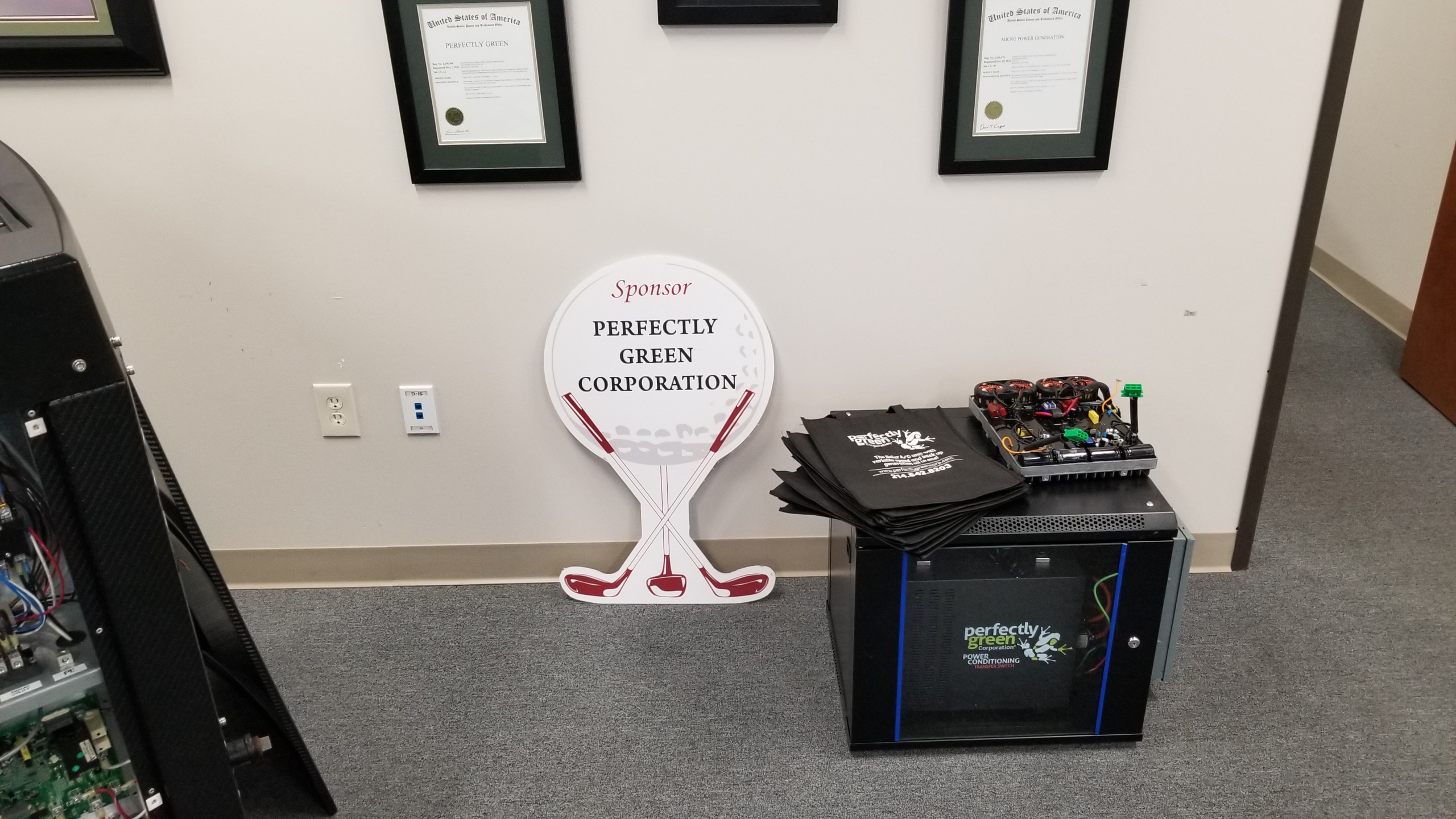 Perfectly Green branded equipment beneath framed patent displays